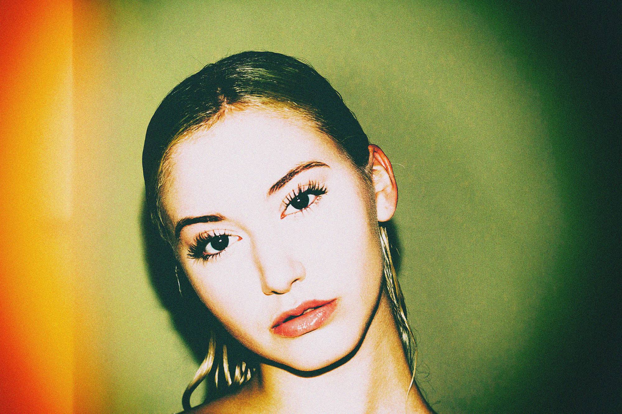 Nocturnal study — head tilted, lips parted, wet hair slicked back, under flash against green