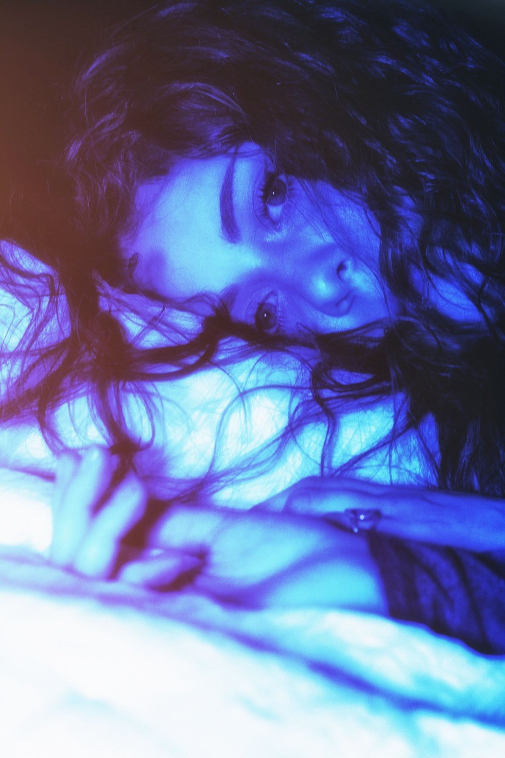 A side-lying close portrait in deep blue light